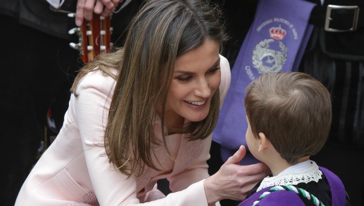 La Reina Letizia hablando con un niño pequeño tras la ceremonia del Premio Cervantes 2017