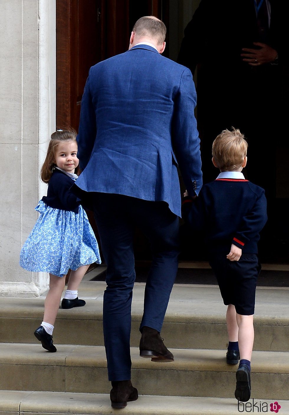 El Príncipe Guillermo de Inglaterra entrando a ver al bebé recién nacido con Jorge y Carlota de Cambridge