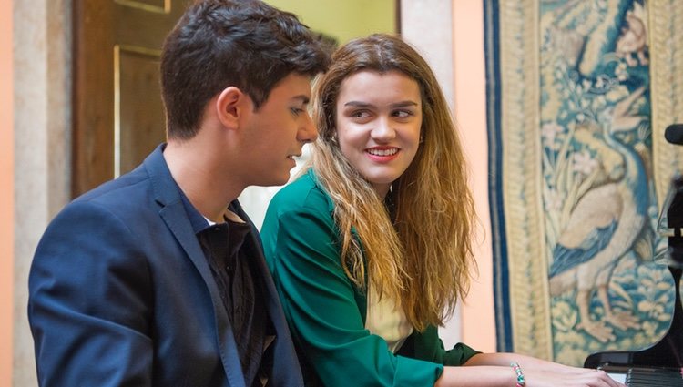 Amaia y Alfred sentados al piano en la embajada de España en Portugal antes de Eurovisión 2018