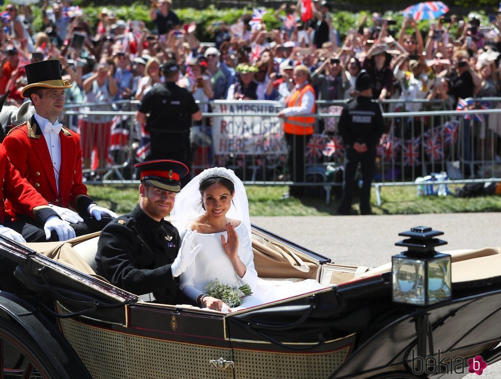 El Príncipe Harry de Inglaterra y Meghan Markle saludando desde el carruaje