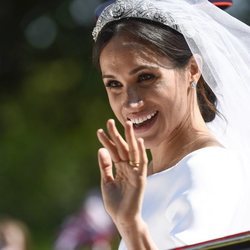 Meghan Markle saluda sonriente desde el carruaje