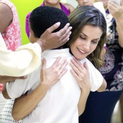 Doña Letizia abraza efusivamente a un niño durante su viaje de cooperación a República Dominicana