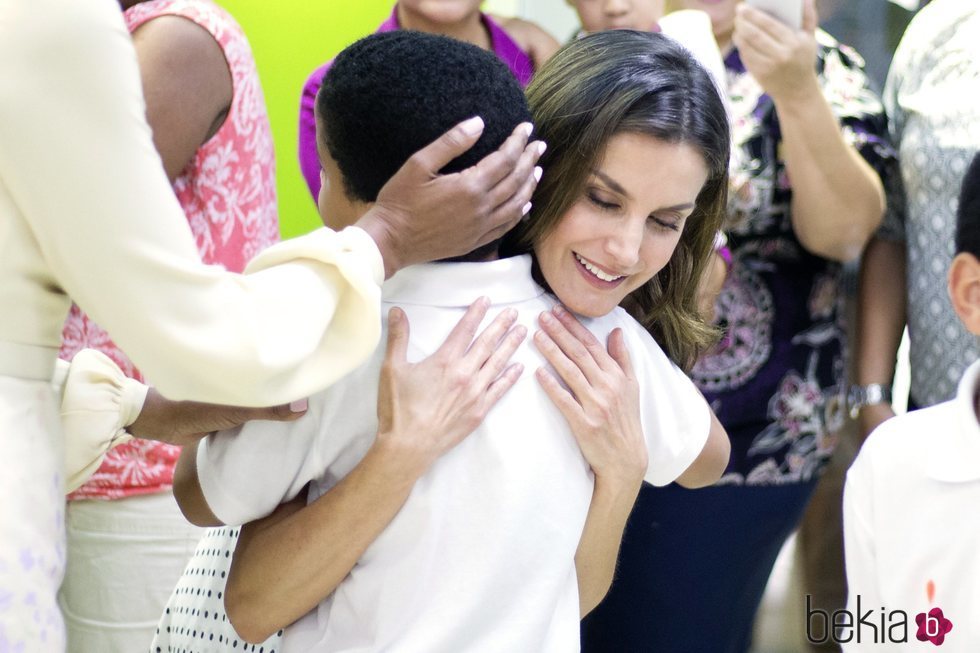 Doña Letizia abraza efusivamente a un niño durante su viaje de cooperación a República Dominicana