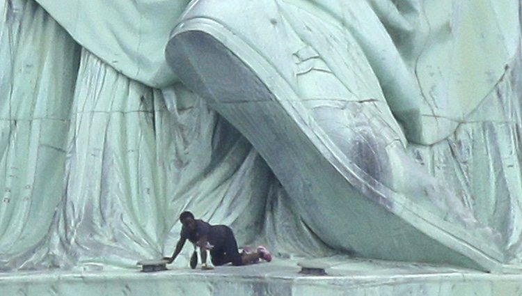 Una mujer escala la Estatua de la Libertad como protesta contra Donald Trump