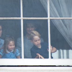 El Príncipe Jorge y la Princesa Carlota con su niñera mirando por una ventana de Buckingham Palace