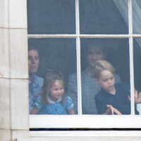 El Príncipe Jorge y la Princesa Carlota con su niñera mirando por una ventana de Buckingham Palace