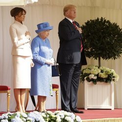 Los Trump con la mano en el corazón junto a la Reina Isabel II