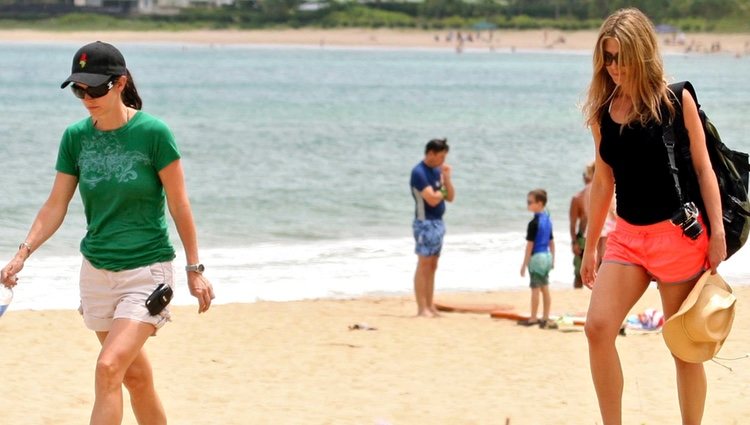 Courteney Cox y Jennifer Aniston paseando por una playa de Hawái