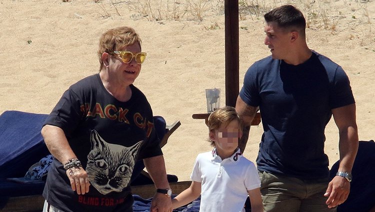 Elton John junto a su hijo Zachary paseando por la playa en sus vacaciones en Cerdeña