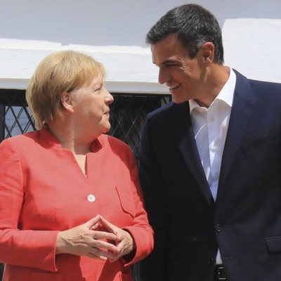 Pedro Sánchez y Angela Merkel se miran sonrientes durante la visita de la canciller al Palacio de los Guzmanes