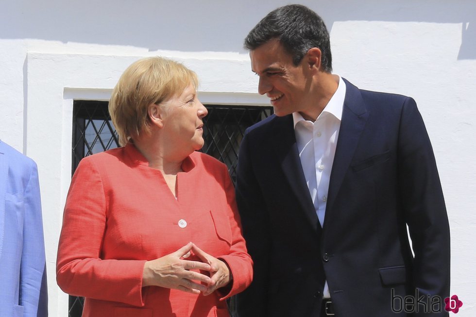 Pedro Sánchez y Angela Merkel se miran sonrientes durante la visita de la canciller al Palacio de los Guzmanes
