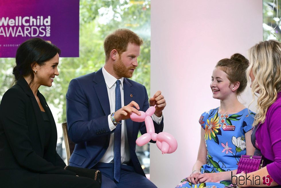 El Príncipe Harry y Meghan Markle con una niña en los Premios WellChild