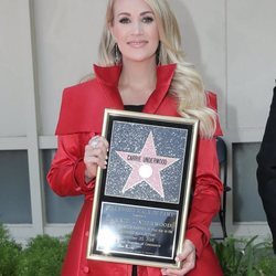 Carrie Underwood posando con su estrella en el Paseo de la Fama de Hollywood