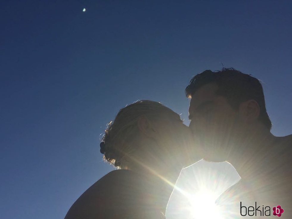 Belén Rueda y Francis Malfatto besándose con el sol de fondo