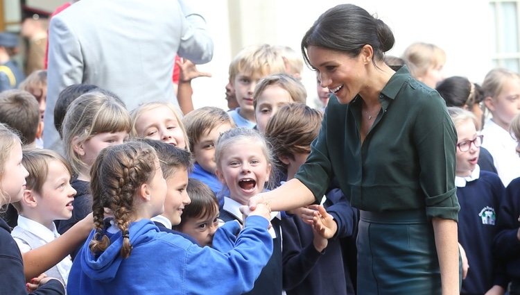 Meghan Markle con unos niños en su primera visita oficial a Sussex