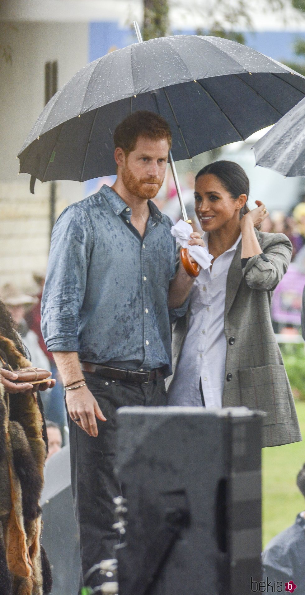 El Príncipe Harry y Meghan Markle con un paraguas en Australia