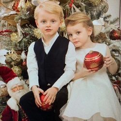 Jacques y Gabriella de Mónaco posando frente a un árbol de Navidad