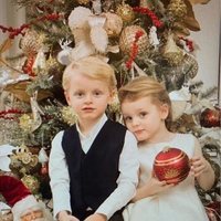 Jacques y Gabriella de Mónaco posando frente a un árbol de Navidad