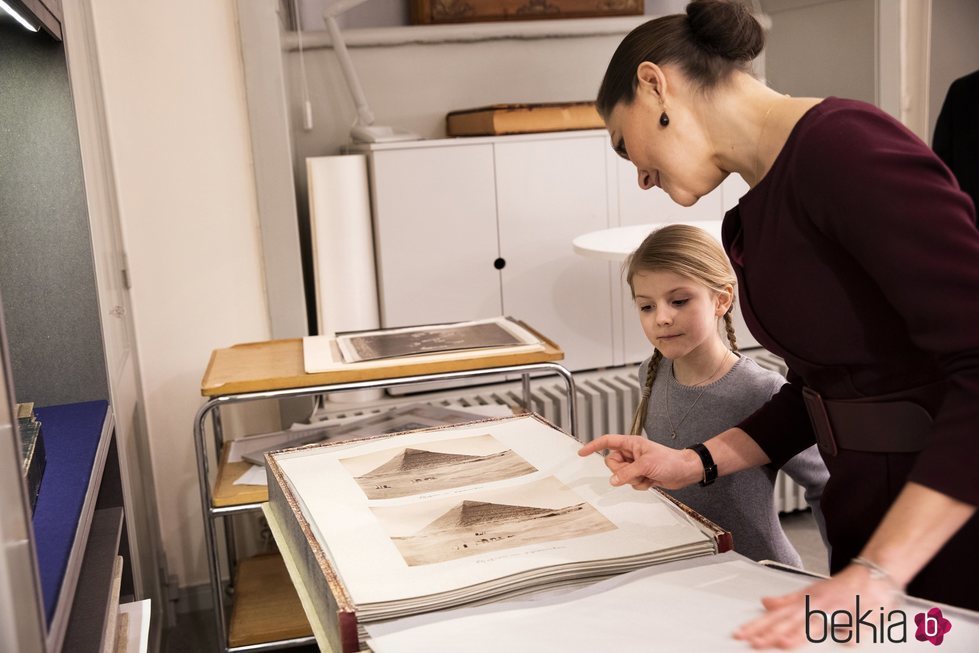 Victoria de Suecia enseña a su hija Estela unas fotos familiares antiguas en la Biblioteca Bernadotte