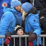 Los Príncipes Haakon y Mette-Marit de Noruega besándose con Estela de Suecia delante de ellos