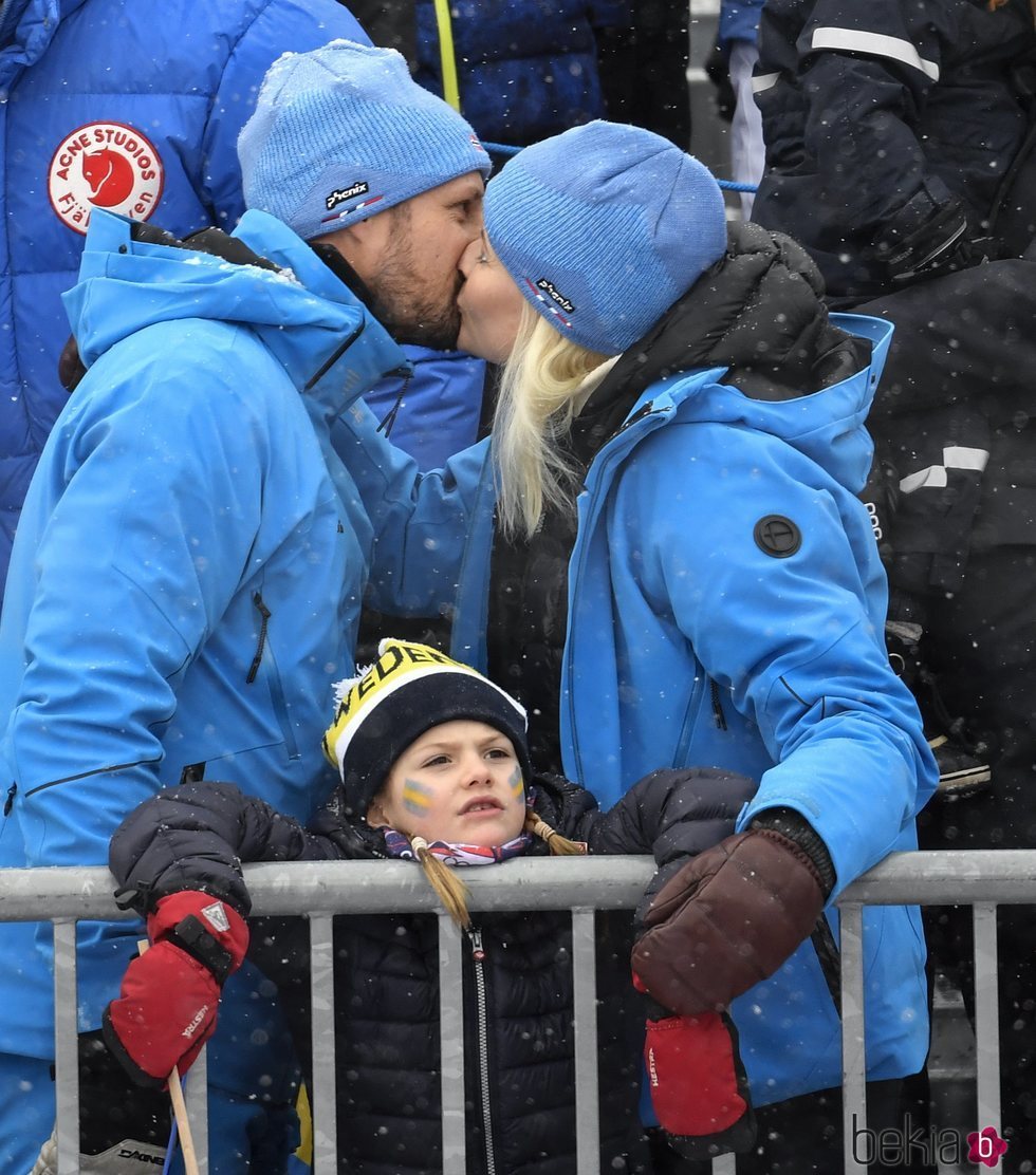 Los Príncipes Haakon y Mette-Marit de Noruega besándose con Estela de Suecia delante de ellos