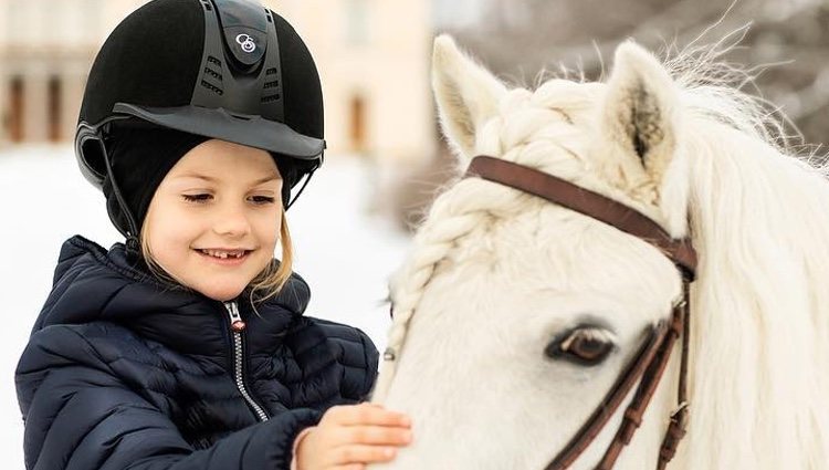 La Princesa Estela de Suecia jugando con un caballo