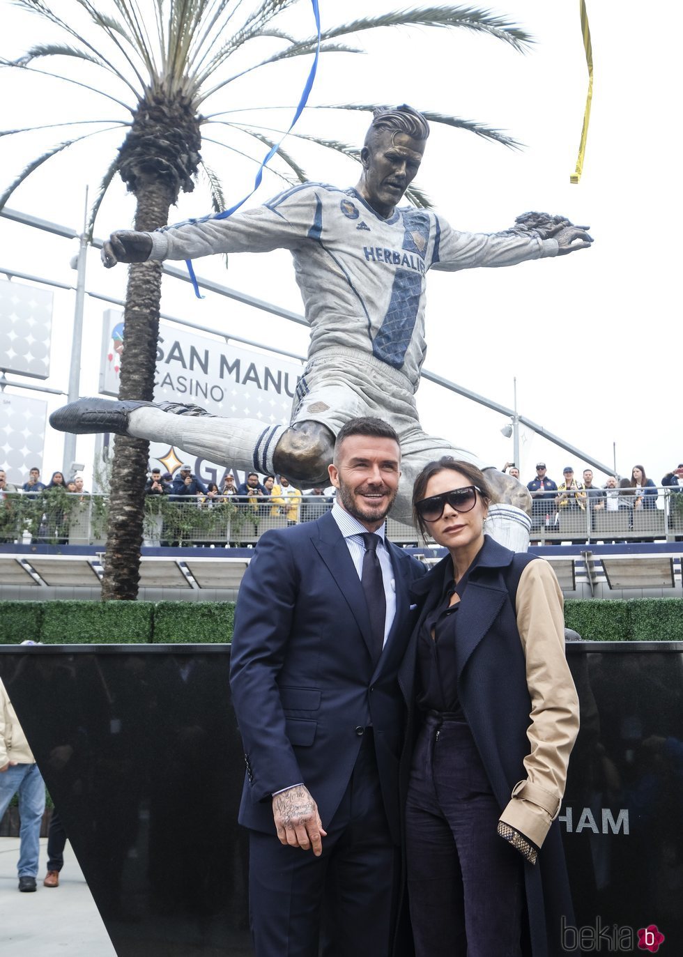 David Beckham y Victoria Beckham posan junto a la estatua del futbolista