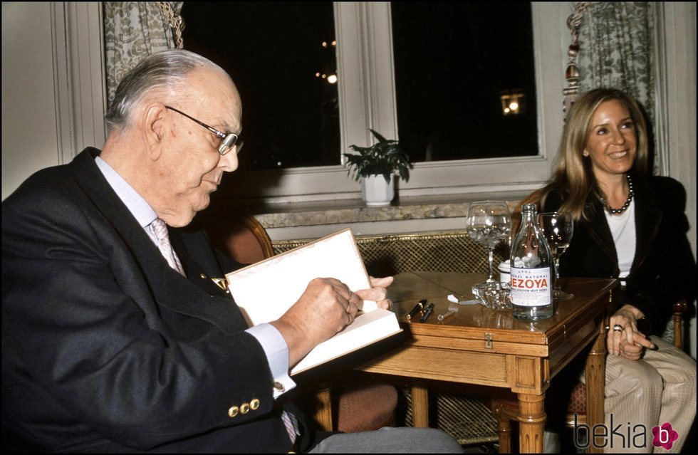 Camilo José Cela firmando un libro en presencia de Marina Castaño
