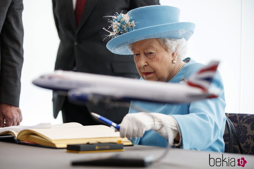 La Reina Isabel firmando el libro de visitas del aeropuerto de Heathrow