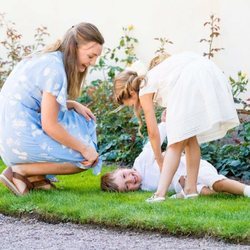 Estela y Oscar de Suecia jugando con su niñera en el Palacio de Solliden