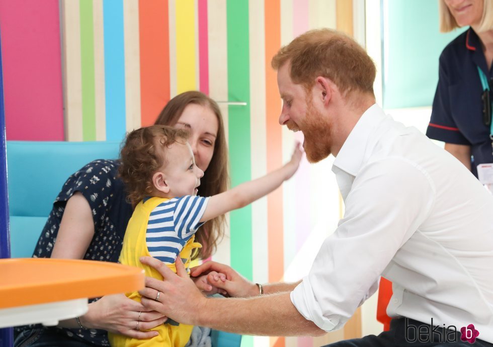 El Príncipe Harry jugando con un niño pequeño