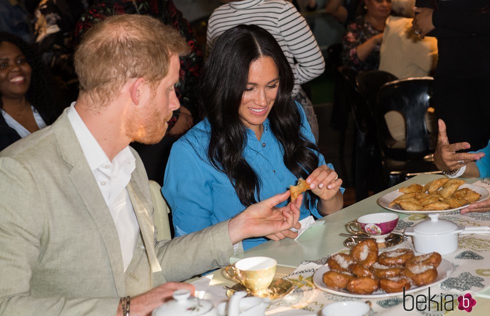 El Príncipe Harry y Meghan Markle comiendo dulces en un centro de acogida de Ciudad del Cabo