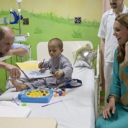 Los Duques de Cambridge jugando con un niño en un hospital infantil en Pakistán