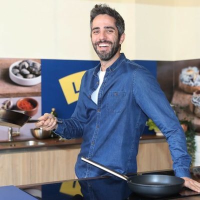 Roberto Leal sostiene una sartén en un evento de cocina