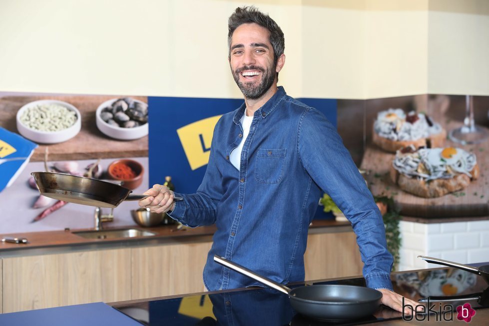 Roberto Leal sostiene una sartén en un evento de cocina