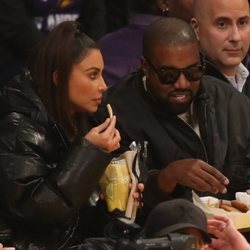 Kim Kardashian y Kanye West comiendo en un partido de baloncesto