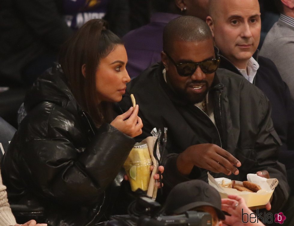 Kim Kardashian y Kanye West comiendo en un partido de baloncesto
