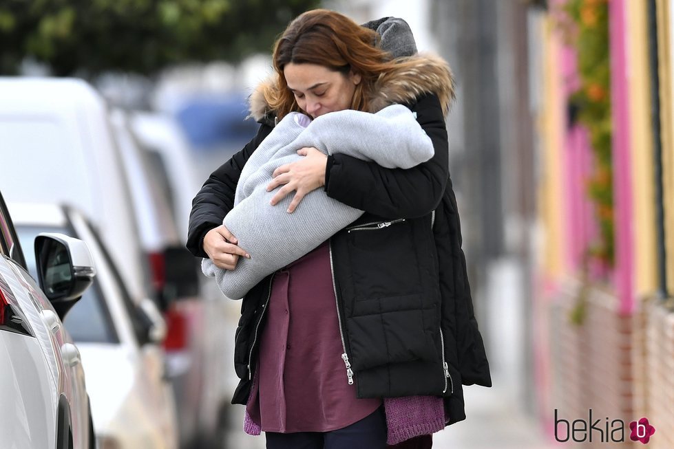 Toñi Moreno dando un beso a su hija Lola mientras pasea con ella en brazos