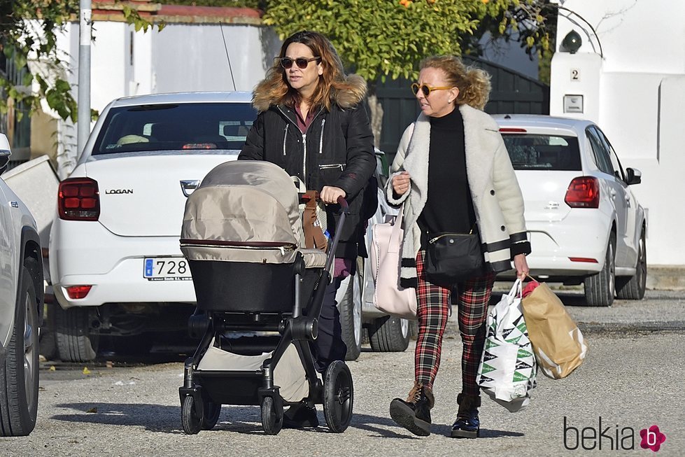 Toñi Moreno paseando a su hija Lola con una amiga