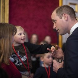 El Príncipe Guillermo con un niño en una recepción en St James Palace