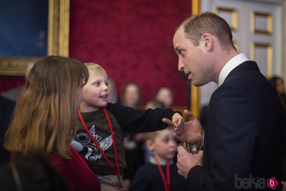 El Príncipe Guillermo con un niño en una recepción en St James Palace