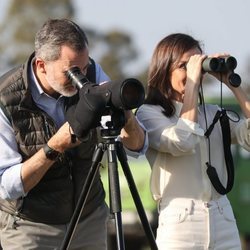 El Rey Felipe VI y la Reina Letizia mirando por unos prismáticos en el Parque Nacional de Doñana