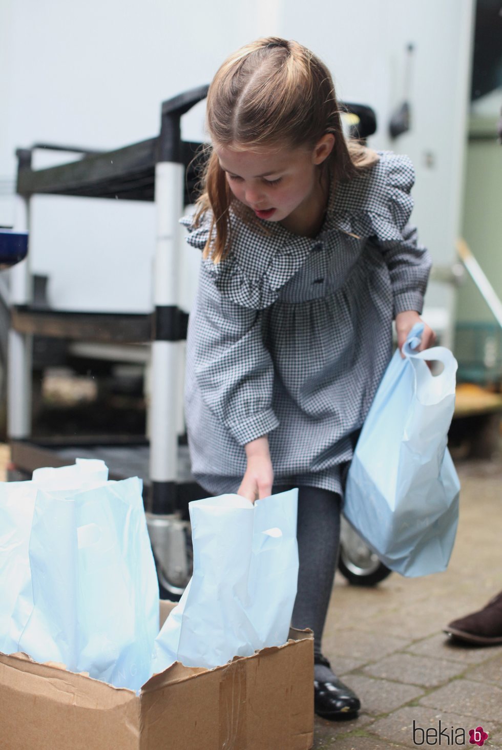 La Princesa Carlota cogiendo bolsas de comida para entregar a personas mayores