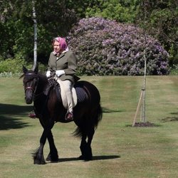 La Reina Isabel montando en caballo en los jardines de Windsor