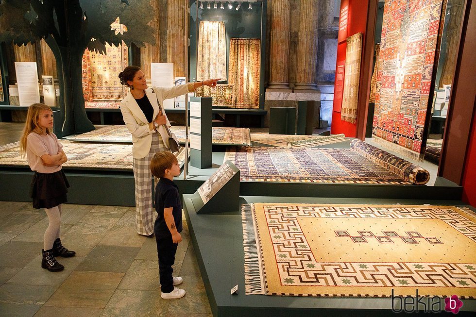 Victoria de Suecia con sus hijos Estela y Oscar de Suecia en una exposición de alfombras