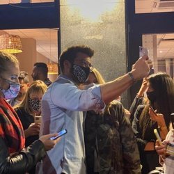 Can Yaman saludando a sus fans en la salida de una pizzería de Milán