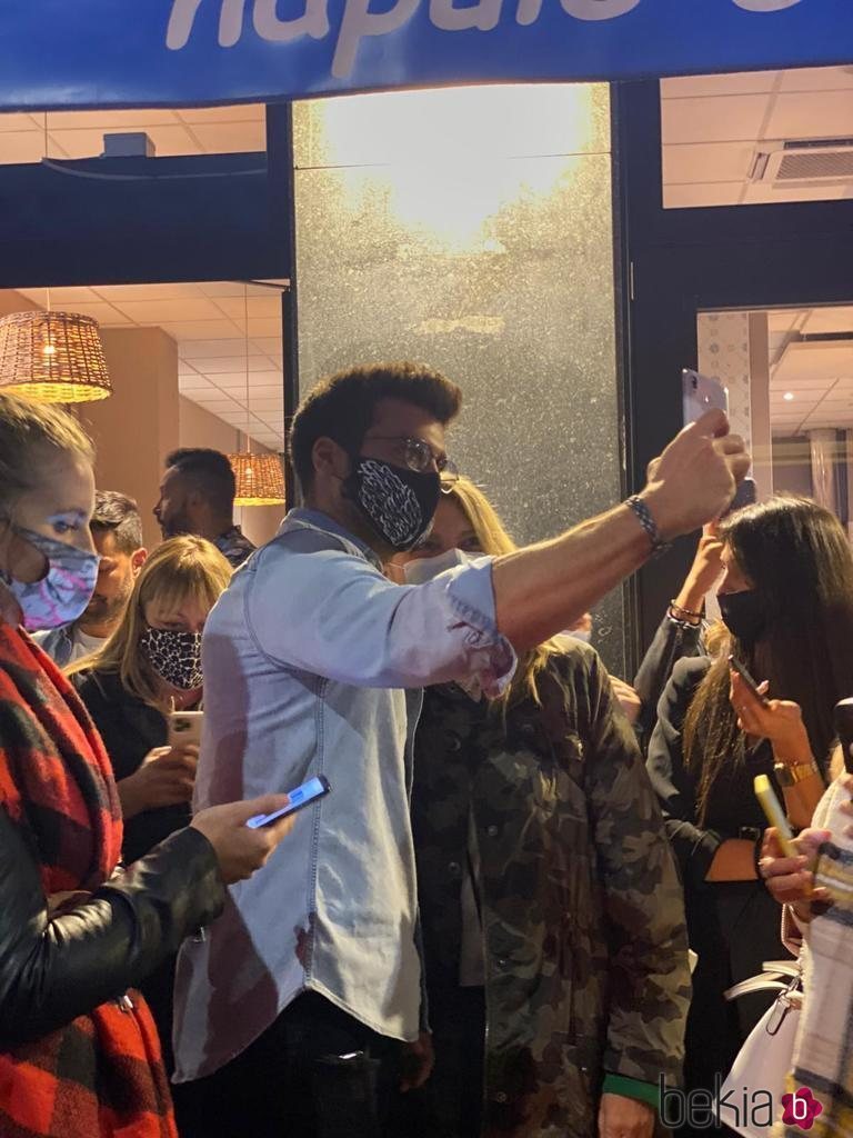 Can Yaman saludando a sus fans en la salida de una pizzería de Milán