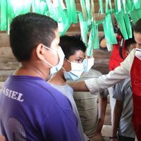 La Reina Letizia con un niño en el Centro de Educación Básica Oswaldo López de Arellano durante su viaje humanitario a Honduras