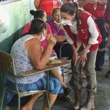 La Reina Letizia escucha el testimonio de una persona refugiada en un albergue en su viaje humanitario a Honduras
