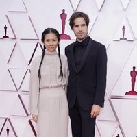 Chloe Zhao y Joshua James Richards en la alfombra roja de los Premios Oscar 2021
